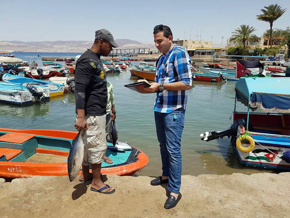 A Royal Marine Conservation Society of Jordan’s employee interviews a fisherman in Aqaba recently (Photo courtesy of JREDS)